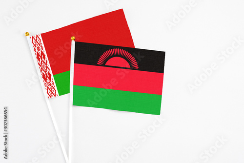 Malawi and Belarus stick flags on white background. High quality fabric, miniature national flag. Peaceful global concept.White floor for copy space. photo