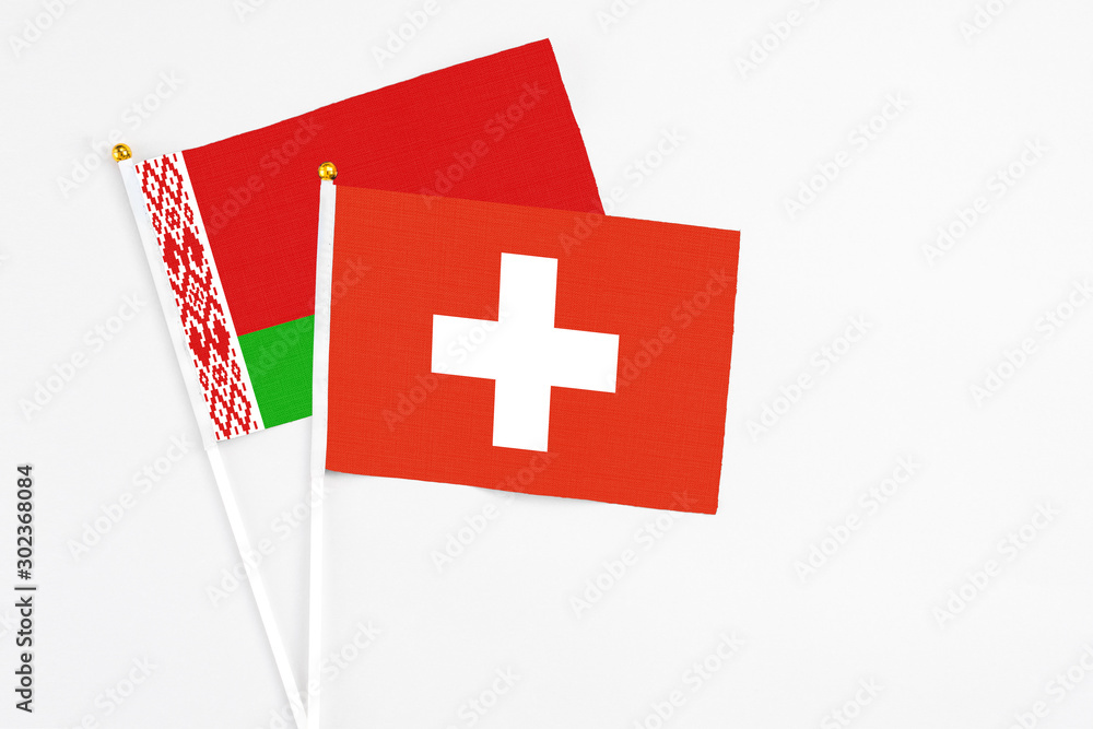 Switzerland and Belarus stick flags on white background. High quality fabric, miniature national flag. Peaceful global concept.White floor for copy space.