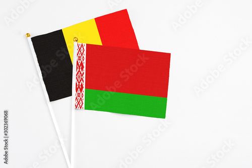 Belarus and Belgium stick flags on white background. High quality fabric, miniature national flag. Peaceful global concept.White floor for copy space. photo