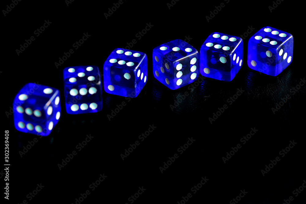Blue dice scattered on a black surface close-up. Gambling background Blue dice scattered on a black surface close-up. Gambling background