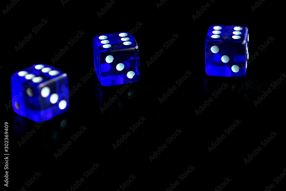 Blue dice scattered on a black surface close-up. Gambling background Blue dice scattered on a black surface close-up. Gambling background