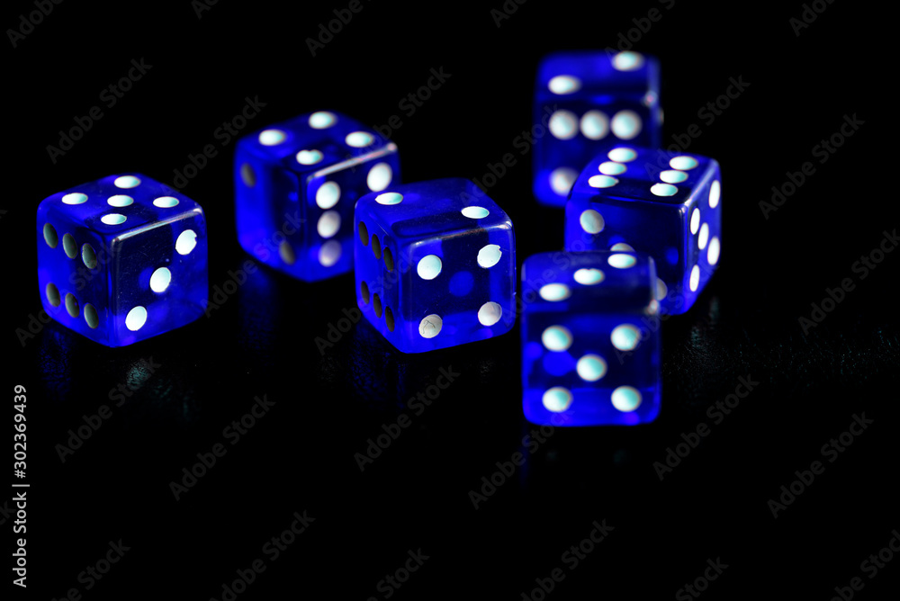 Blue dice scattered on a black surface close-up. Gambling background Blue dice scattered on a black surface close-up. Gambling background