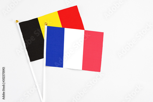 France and Belgium stick flags on white background. High quality fabric, miniature national flag. Peaceful global concept.White floor for copy space. photo