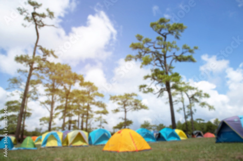 the tourist camping site. Camping point hiking at tent among meadow under the forest mountain sunset. travel summer holidays concept. empty space for text. 