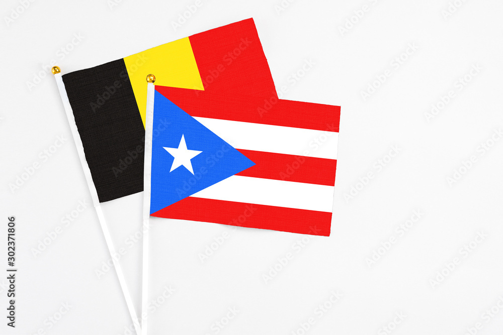 Puerto Rico and Belgium stick flags on white background. High quality fabric, miniature national flag. Peaceful global concept.White floor for copy space. Puerto Rico and Belgium stick flags on white background. High quality fabric, miniature national flag. Peaceful global concept.White floor for copy space.