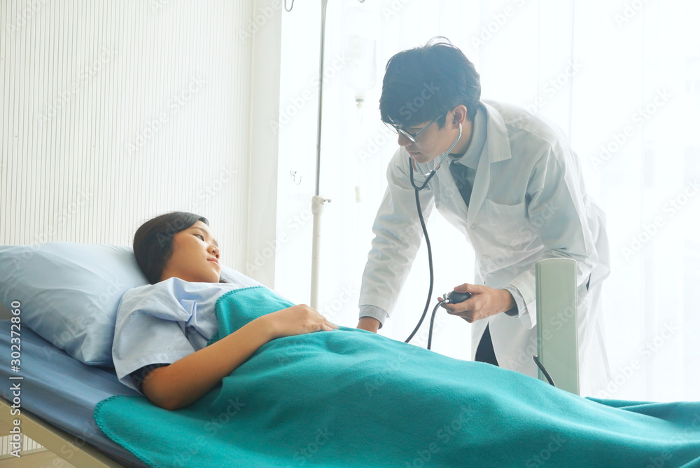 Doctor is measuring the pulse of asian patient woman who is lying in bed. Doctor is measuring the pulse of asian patient woman who is lying in bed.