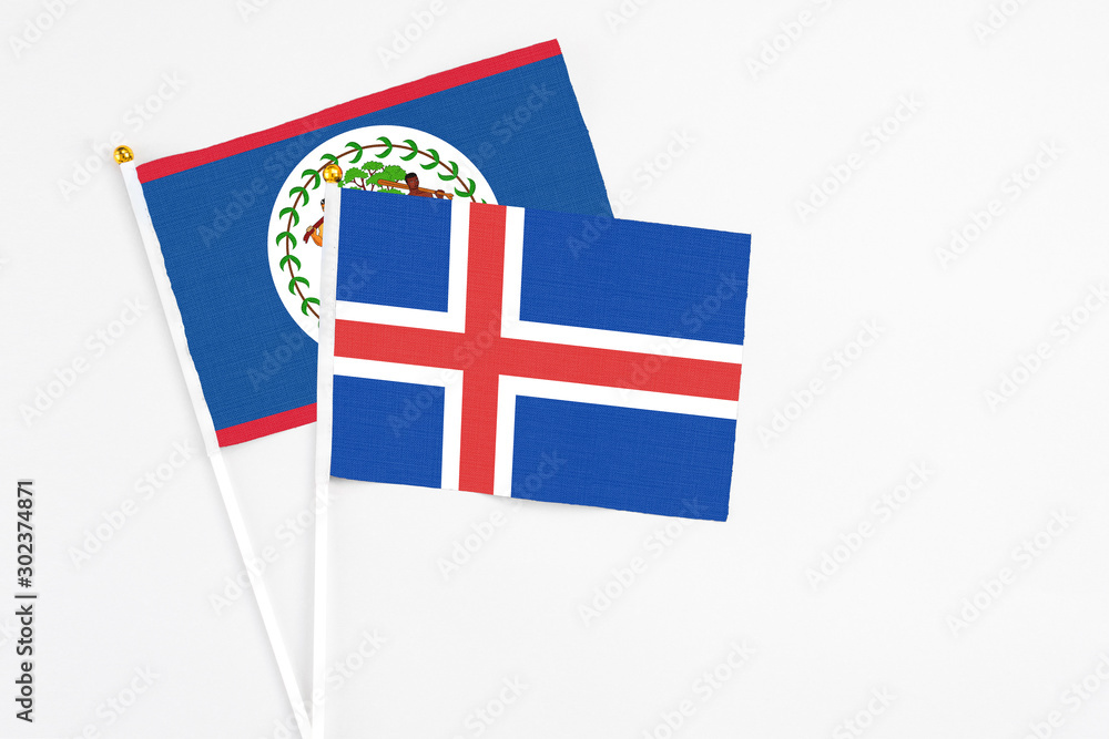 Iceland and Belize stick flags on white background. High quality fabric, miniature national flag. Peaceful global concept.White floor for copy space.