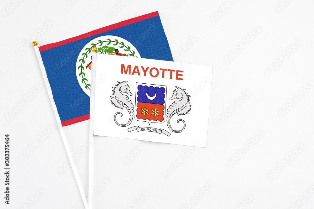 Mayotte and Belize stick flags on white background. High quality fabric, miniature national flag. Peaceful global concept.White floor for copy space.
