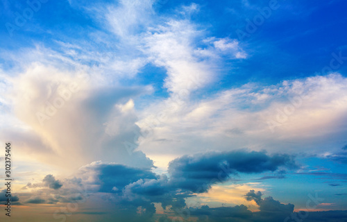 White clouds on blue sky background close up, colorful sunrise cloudy skies, beautiful azure and yellow cloudiness heaven on sunset backdrop, bright morning or evening sunlight cloudscape, copy space
