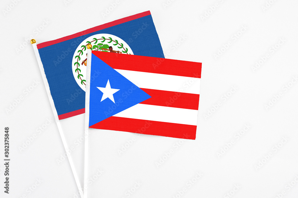 Puerto Rico and Belize stick flags on white background. High quality fabric, miniature national flag. Peaceful global concept.White floor for copy space. Puerto Rico and Belize stick flags on white background. High quality fabric, miniature national flag. Peaceful global concept.White floor for copy space.
