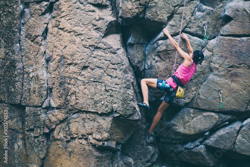 Fototapeta Naklejka Na Ścianę i Meble -  The girl climbs the granite rock.