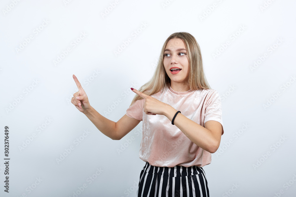 Portrait of cheerful young woman in nice clothes rising fingers, like winner isolated on white wall background in studio. People sincere emotions, lifestyle concept. Portrait of cheerful young woman in nice clothes rising fingers, like winner isolated on white wall background in studio. People sincere emotions, lifestyle concept.