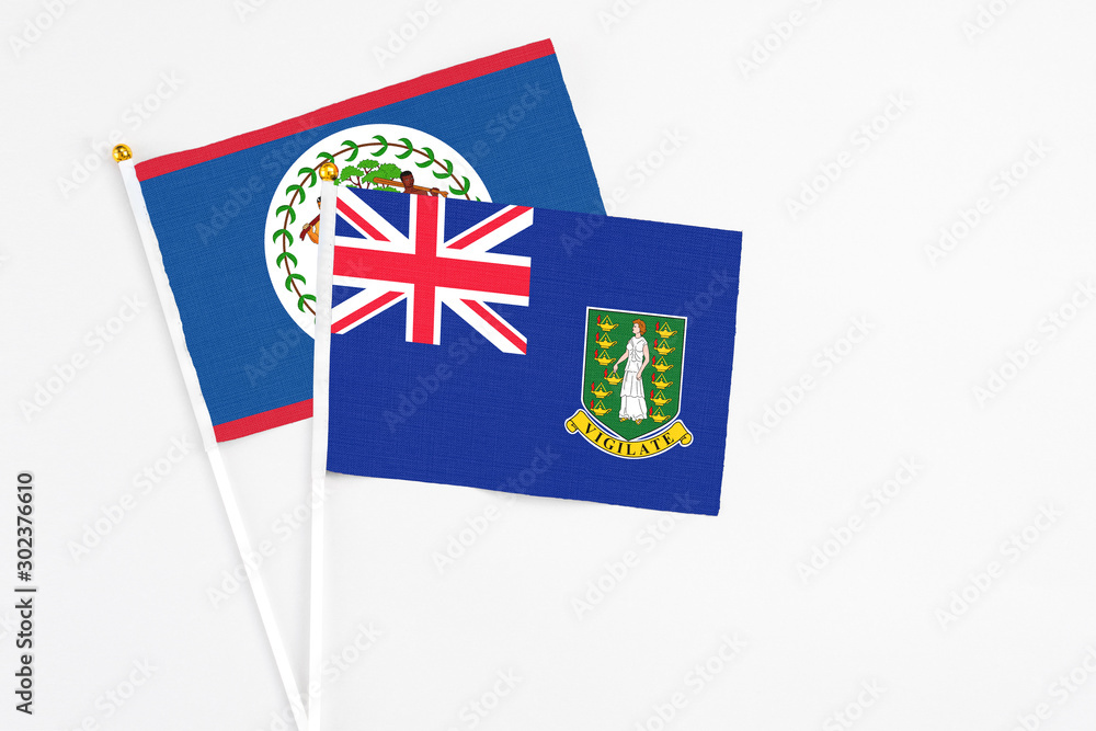 Fototapeta premium British Virgin Islands and Belize stick flags on white background. High quality fabric, miniature national flag. Peaceful global concept.White floor for copy space.