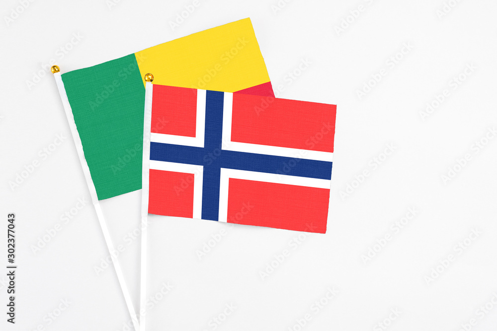 Bouvet Islands and Benin stick flags on white background. High quality fabric, miniature national flag. Peaceful global concept.White floor for copy space.