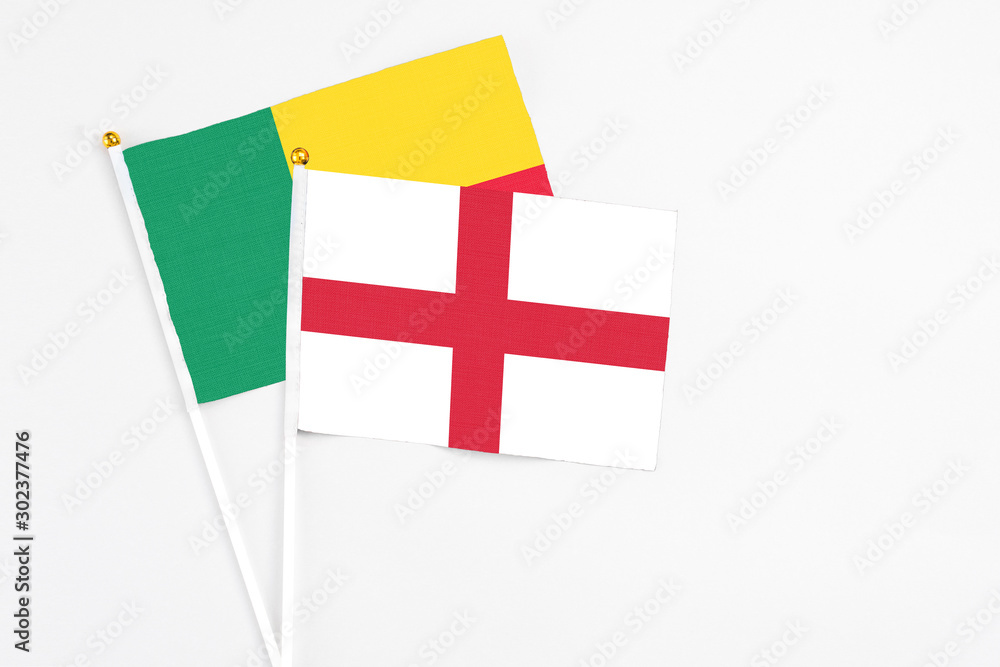 England and Benin stick flags on white background. High quality fabric, miniature national flag. Peaceful global concept.White floor for copy space.