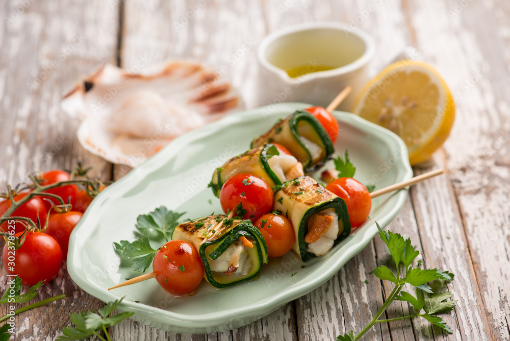 skewer rolled up with zucchinis scallop and tomatoes
