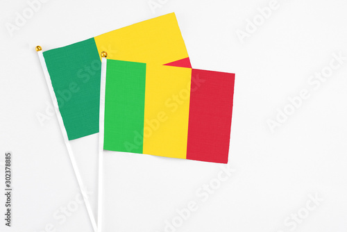 Mali and Benin stick flags on white background. High quality fabric, miniature national flag. Peaceful global concept.White floor for copy space.