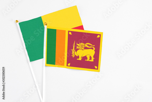 Sri Lanka and Benin stick flags on white background. High quality fabric, miniature national flag. Peaceful global concept.White floor for copy space.