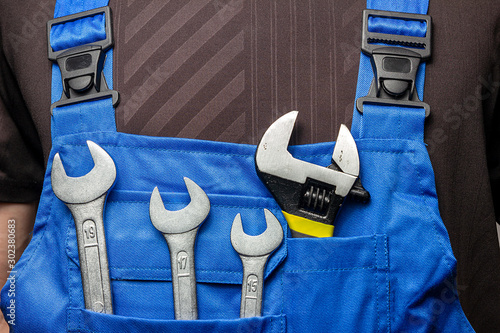Handyman in uniform with construction tools and  equipments. Men tools background.