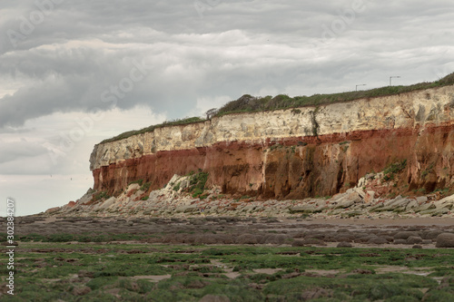 Colorful orange rocky cliffs from limestone and low tide sea, high cliffs by the ocean Dover Hunstanton