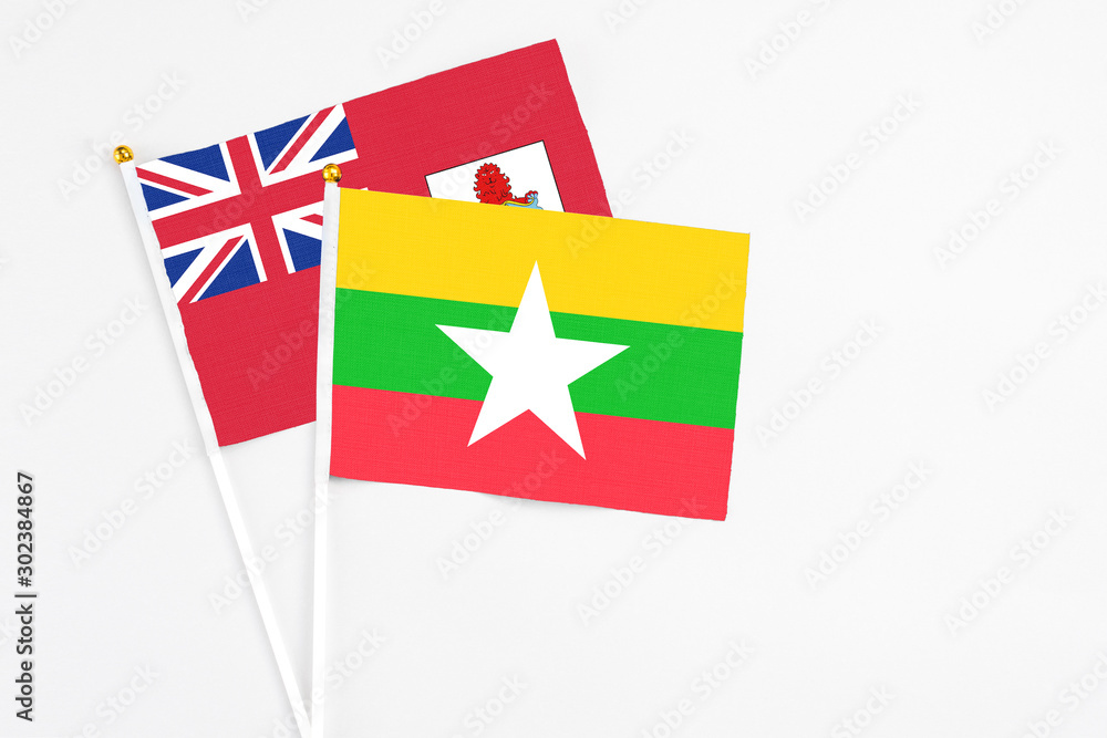 Fototapeta premium Myanmar and Bermuda stick flags on white background. High quality fabric, miniature national flag. Peaceful global concept.White floor for copy space.
