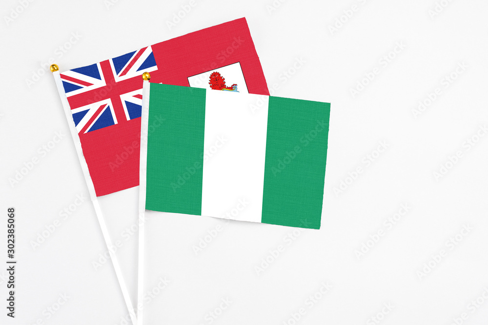 Nigeria and Bermuda stick flags on white background. High quality fabric, miniature national flag. Peaceful global concept.White floor for copy space. Nigeria and Bermuda stick flags on white background. High quality fabric, miniature national flag. Peaceful global concept.White floor for copy space.