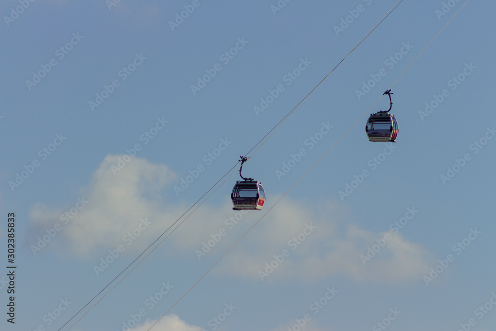 High hanging ski cableway in mountains, big cabin gondola lift running on wires ropeway