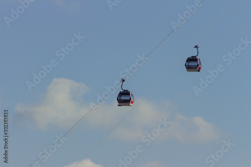 High hanging ski cableway in mountains, big cabin gondola lift running on wires ropeway