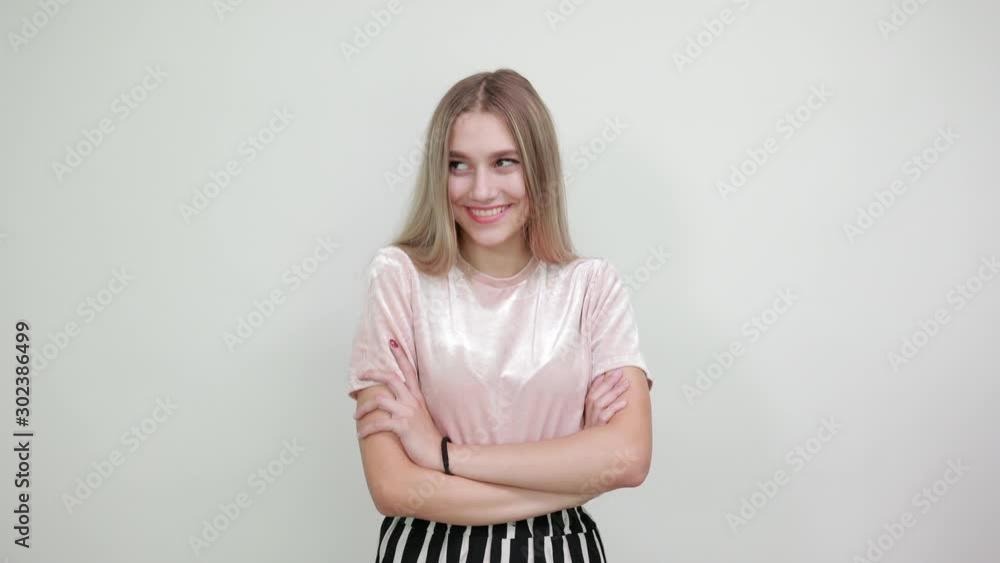Side view of successful confident young woman in nice casual shirt hugging herself with opened eyes over isolated on white wall background in studio. People lifestyle concept. Side view of successful confident young woman in nice casual shirt hugging herself with opened eyes over isolated on white wall background in studio. People lifestyle concept.
