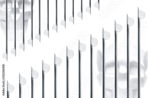 Needles of syringes and vaccine droplets against skulls on white background  closeup  isolated