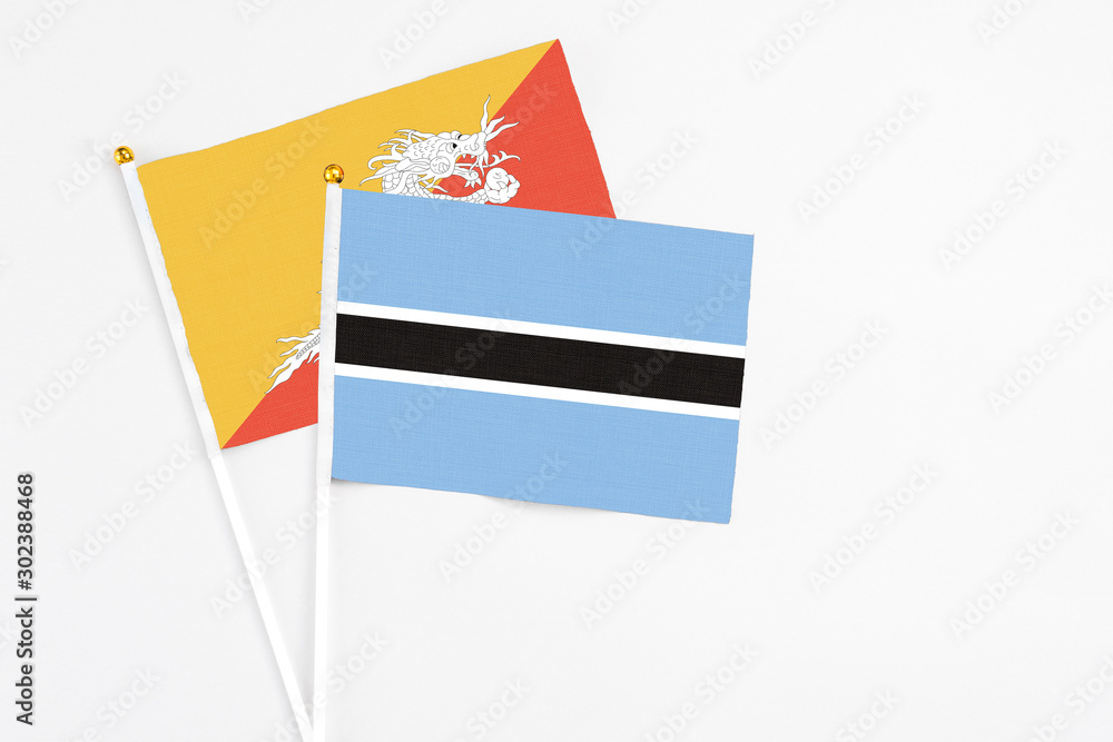 Botswana and Bhutan stick flags on white background. High quality fabric, miniature national flag. Peaceful global concept.White floor for copy space. Botswana and Bhutan stick flags on white background. High quality fabric, miniature national flag. Peaceful global concept.White floor for copy space.
