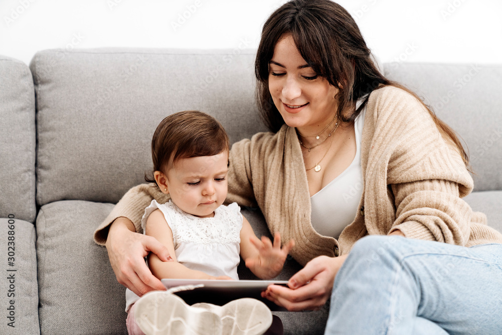 Happy family laughing and playing at home with tablet