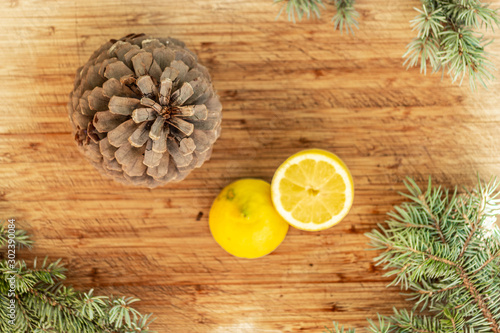 Big Pine cone and lemons on wooden table flatlay, top view 