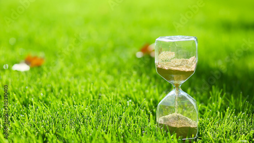 Foto Hourglass on green grass outdoors