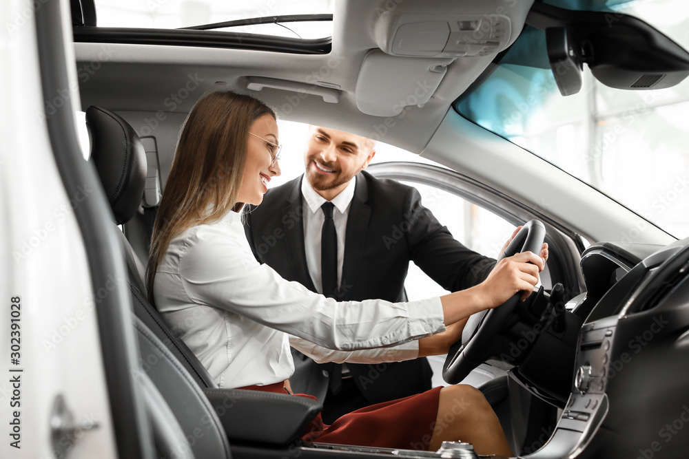 Woman choosing new car in salon Woman choosing new car in salon