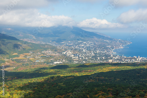 View of Yalta on coast of Black Sea and autumn forest from Ai-Petri mountain on foggy and cloudy sunny day. Crimea, Russia © Irin Fierce