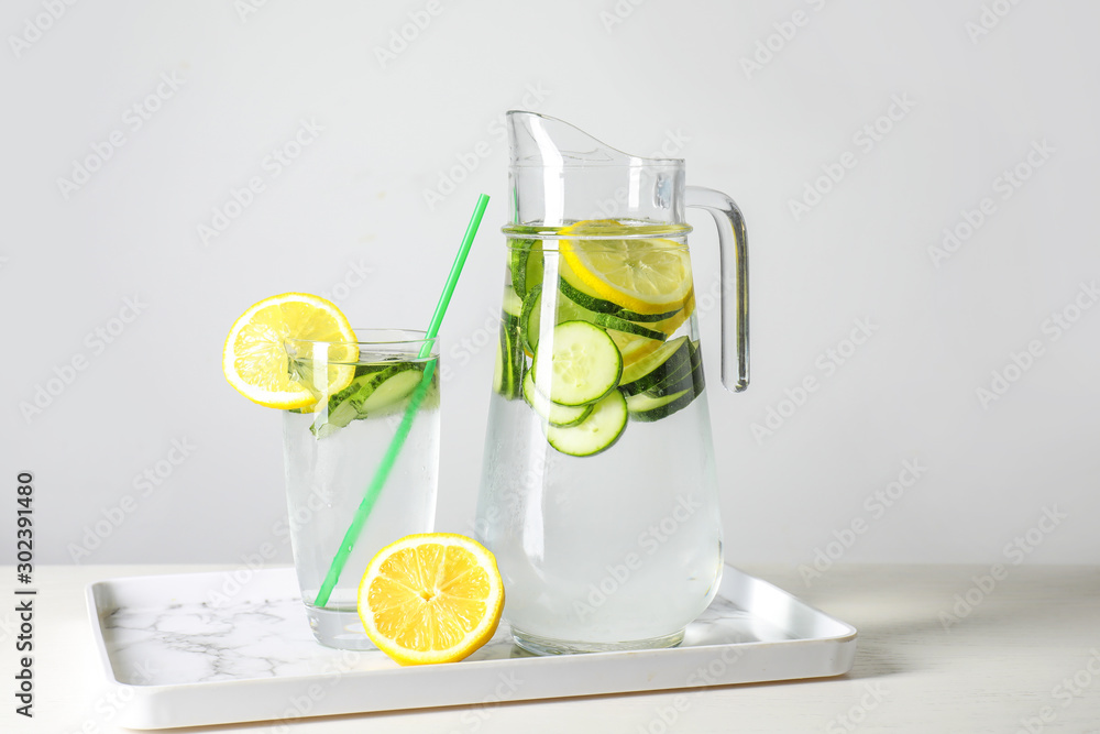 Fototapeta premium Jug and glass of healthy infused water on table
