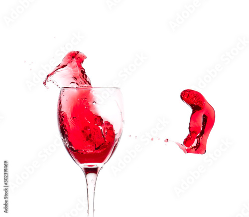 Red wine splash in glass wi...