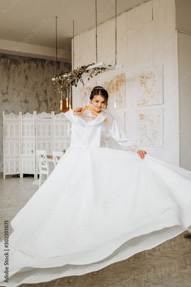 white coat holds her wedding dress 