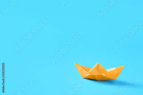 Origami boat on color background