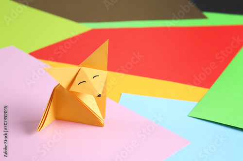Origami fox on color background