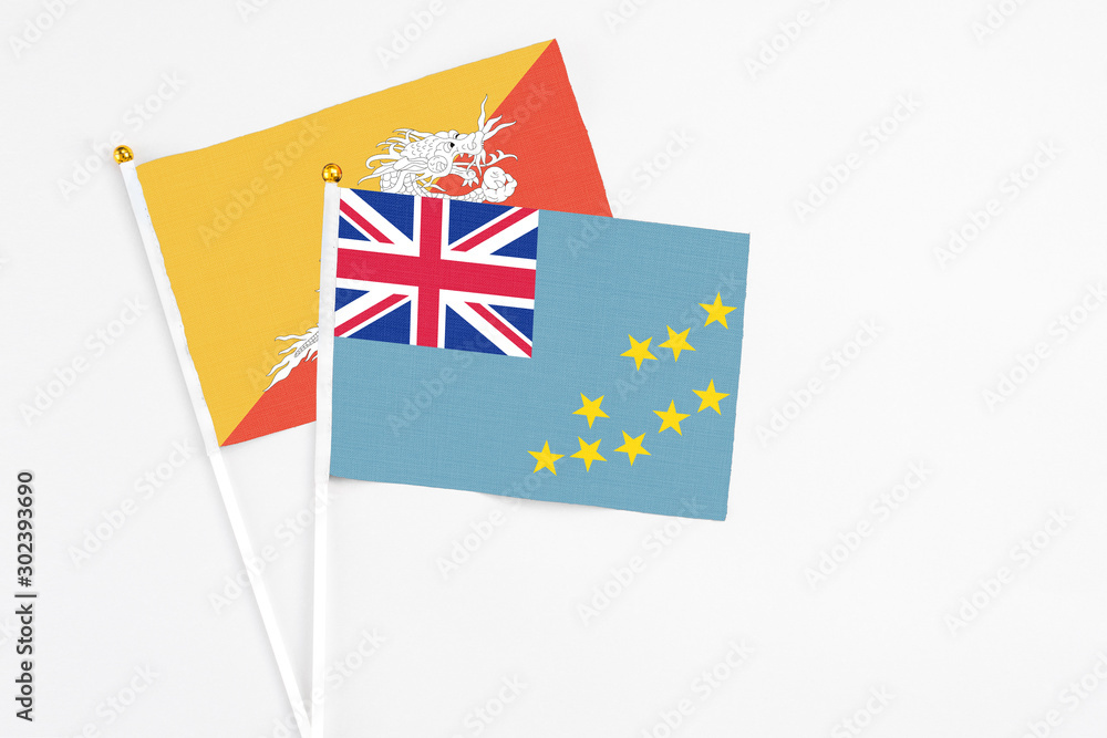 Tuvalu and Bhutan stick flags on white background. High quality fabric, miniature national flag. Peaceful global concept.White floor for copy space. Tuvalu and Bhutan stick flags on white background. High quality fabric, miniature national flag. Peaceful global concept.White floor for copy space.