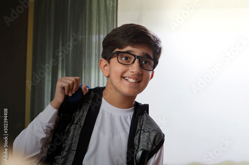 Portrait of a happy young boy holding a backpack. (Children) 	 photo