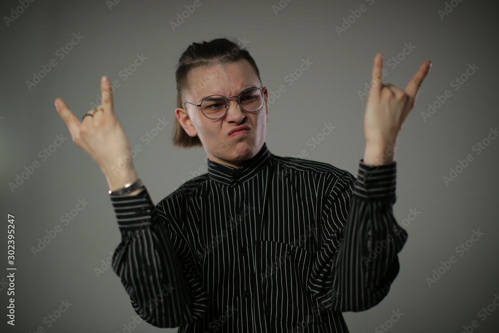 A young guy in a black shirt and glasses shows cool gestures A young guy in a black shirt and glasses shows cool gestures
