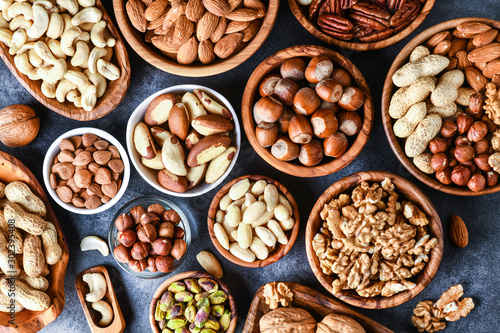 Photography Mixed nuts in wooden bowls on black stone table