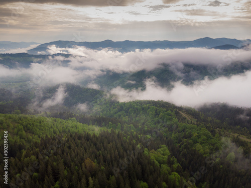 Aerial view of mist, cloud and fog hanging over a lush rain forest after a storm