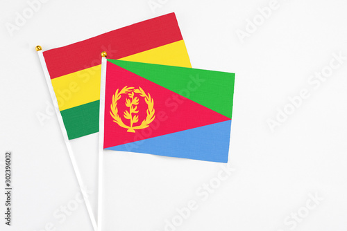 Eritrea and Bolivia stick flags on white background. High quality fabric  miniature national flag. Peaceful global concept.White floor for copy space.