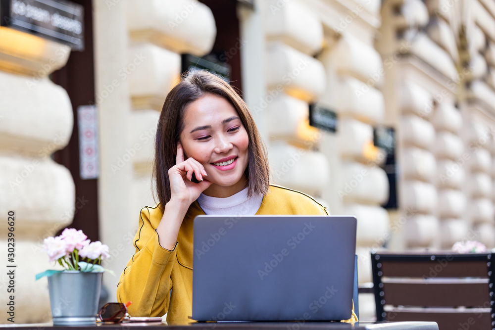 Young Asian businesswoman is working in a cafeteria in her break. Woman taking a break. Enjoying work from coffee shop. Doing Business From coffee shop Young Asian businesswoman is working in a cafeteria in her break. Woman taking a break. Enjoying work from coffee shop. Doing Business From coffee shop