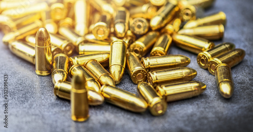 Round and bullets ammunition on stone table. Bullet pile background. Shooting sports 9mm technology.