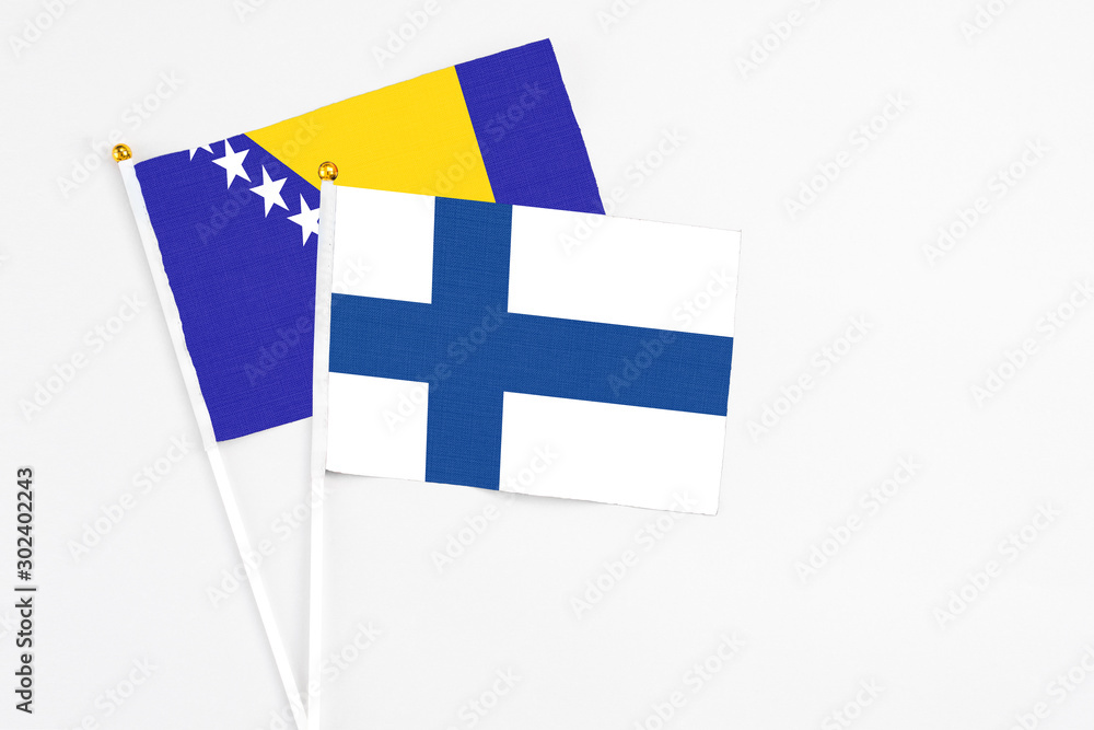Finland and Bosnia Herzegovina stick flags on white background. High quality fabric, miniature national flag. Peaceful global concept.White floor for copy space.